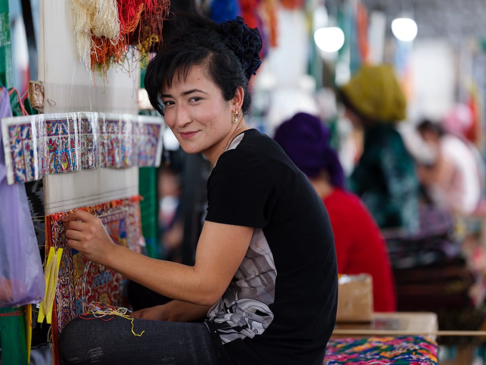 Uzbek woman working on a silk carpet