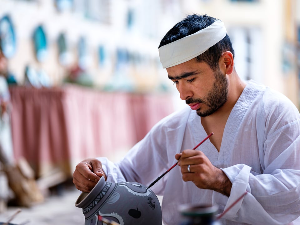 A ceramics apprentice from Uzbekistan, drawing on a pot. Captured with Fujifilm GFX 50R