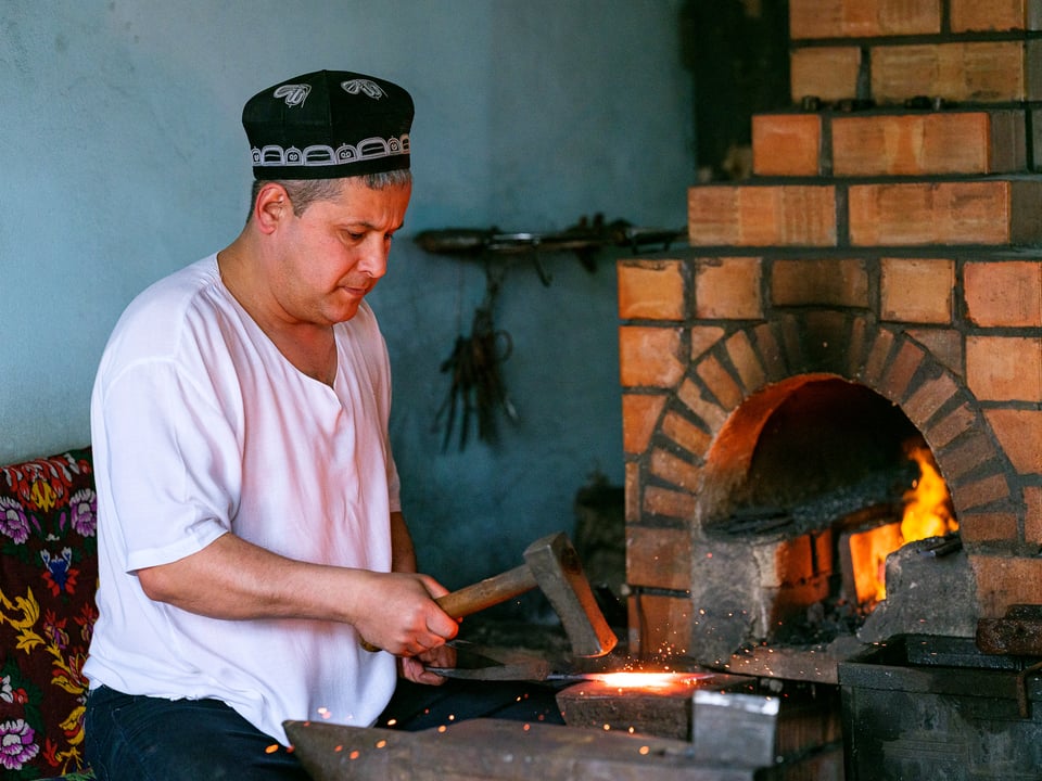 Blacksmith apprentice forging a knife in Andijan