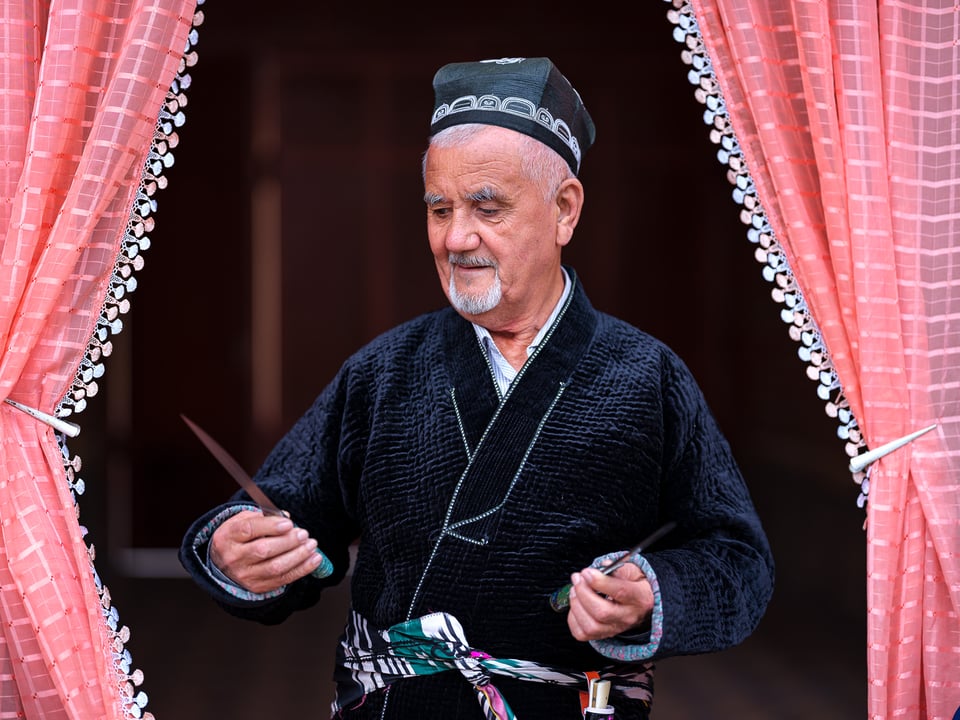 A master blacksmith from Andijan, Uzbekistan, holding a knife he made