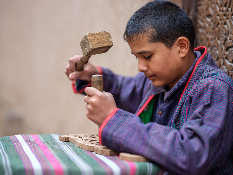 An Uzbek boy doing woodwork, Khiva, Uzbekistan