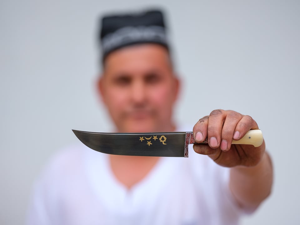 Apprentice blacksmith holding knife, Andijan, Uzbekistan