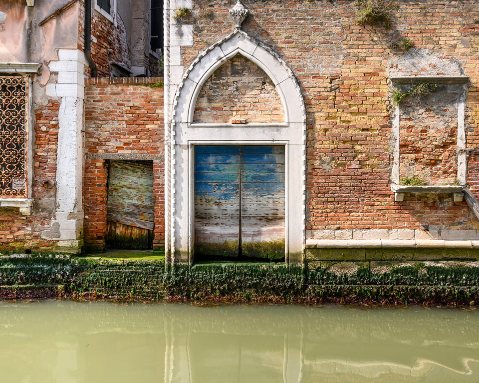 A simple study of beautifully designed and executed architectural detail, set off against ever varied brick work, a visually interesting blue door, much weed and the typical murky green water of a tranquil canal.