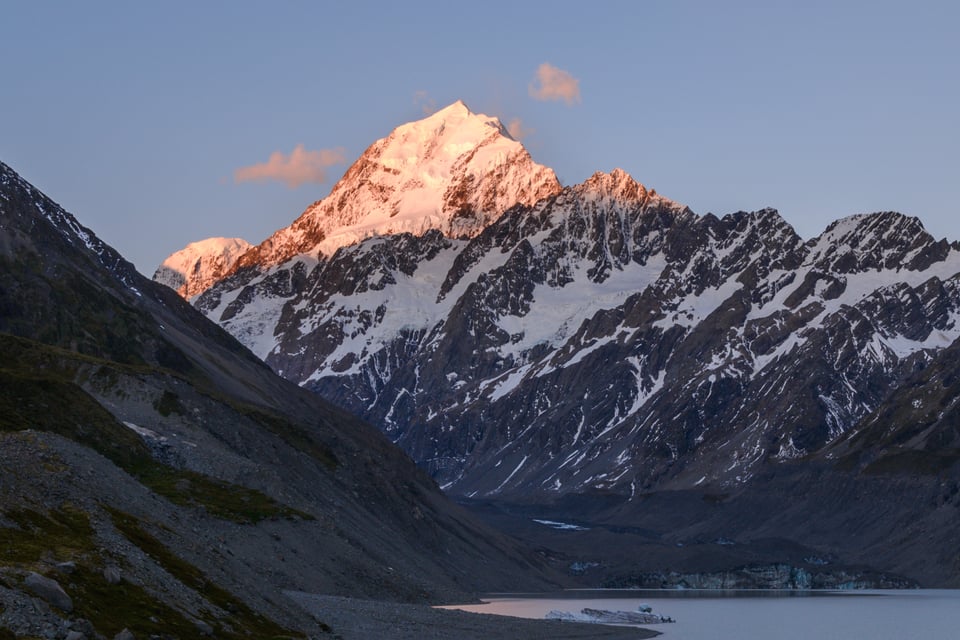 Mountain with bright sunlit peak at sunset