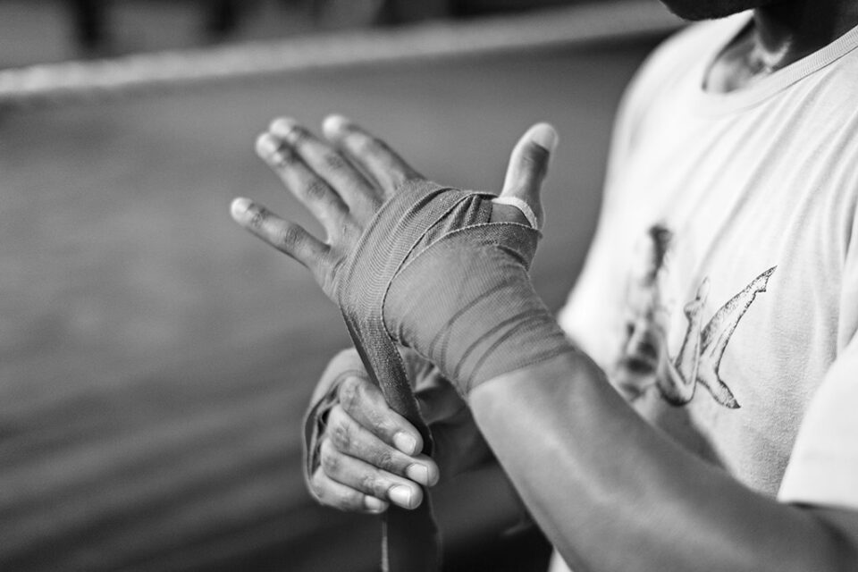 One of the young boxers prepares for the training session by putting bandages on his hands. They keep the hands and joints warm and less breakable.