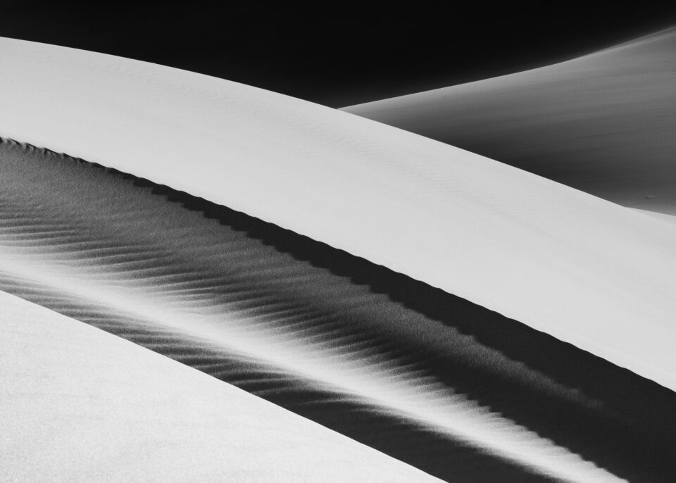 This abstract black and white photo of sand dunes has a peaceful, balanced composition.