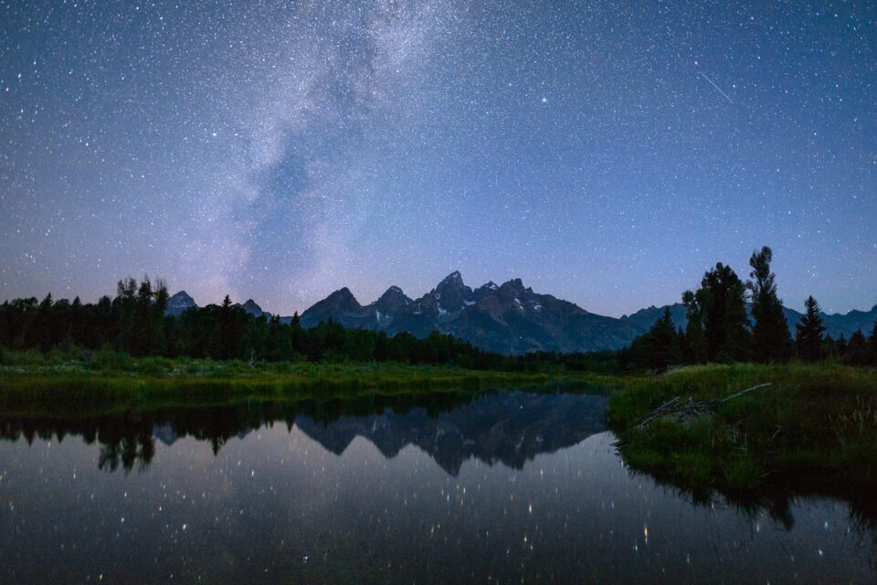 Milky Way photography requires a good understanding of camera settings and camera equipment. Here, the Milky Way rises over the Grand Teton mountains in Wyoming.