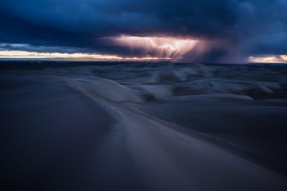 Landscape photography in challenging conditions can lead to beautiful pictures. Here, lightning strikes over Great Sand Dunes National Monument in Colorado.