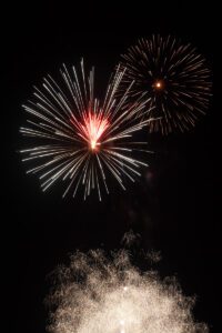 Two fireworks in the sky against black background