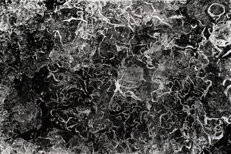 Snow and ice make great abstract macro photography subjects up close. This black and white photo shows bubbles in a piece of ice.