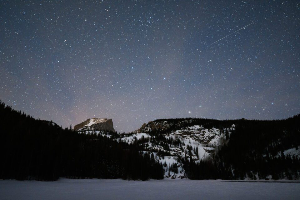 Because it gets dark early, winter can be a great time to capture celestial events like meteor showers over a landscape.