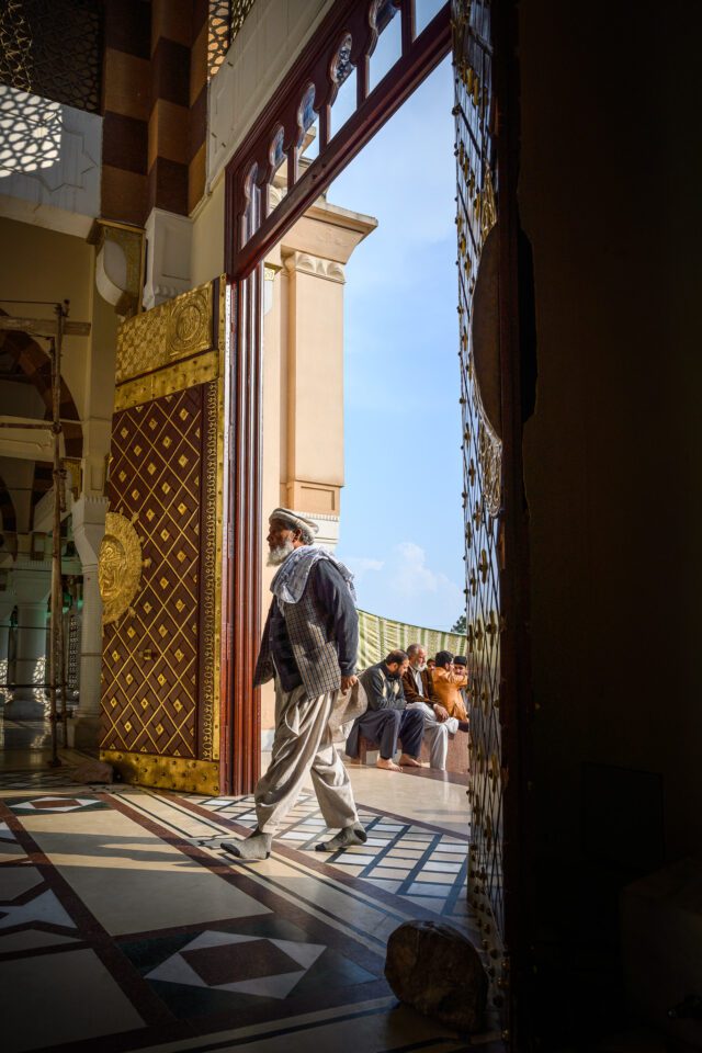 Man walks past ornate doors to enter the shrine