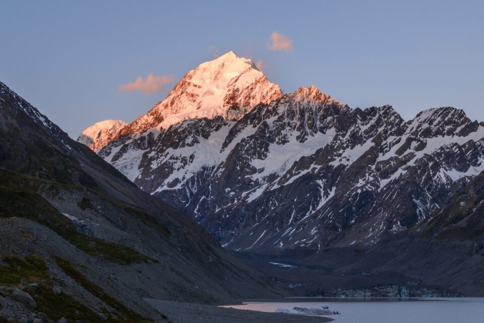 Mountain with bright sunlit peak at sunset