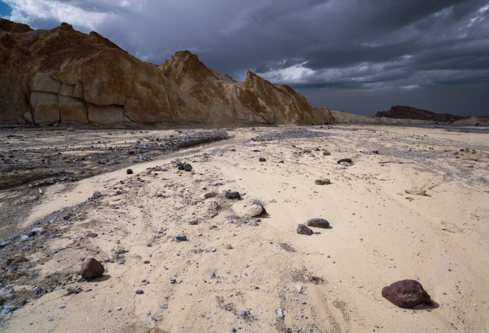 Premier plan lumineux avec lumière du soleil et ciel sombre avec tempête Death Valley