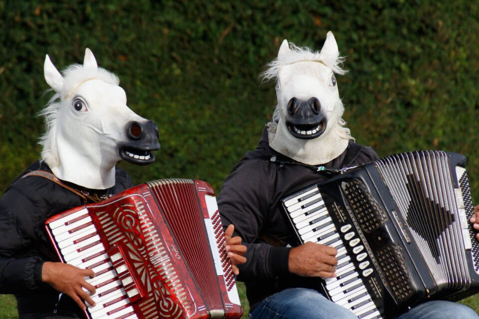 people with horse masks playing accordion 